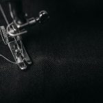 Photo by Alexander Andrews photo of gray sewing machine foot lock with thread on black cloth